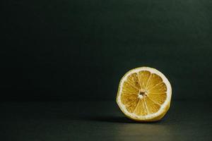 Half of a lemon on a green background photo