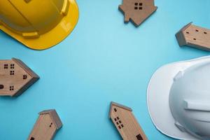 Flat lay of hardhats and wooden houses
