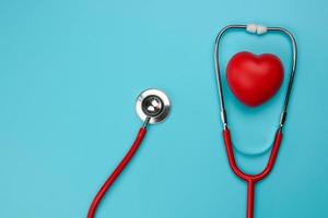 Flat lay of a stethoscope and heart on a blue background photo