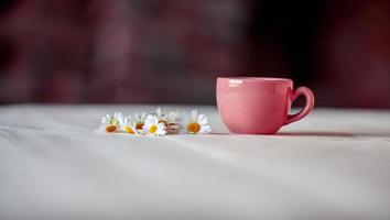 herbal tea with dried chamomile flowers, old wood table background photo