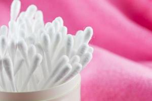 Close up of cotton Buds isolated on pink background. photo