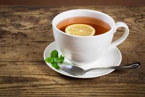 Cup of tea with mint leaf and lemon photo