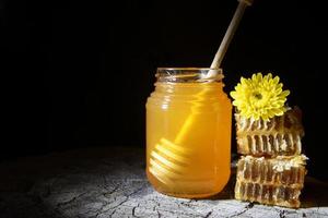 Tarro de miel y panales sobre un fondo de madera