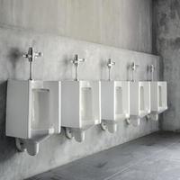 Line of white porcelain urinals in public toilets photo