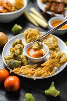 Deep-fried broccoli served with tomato sauce photo