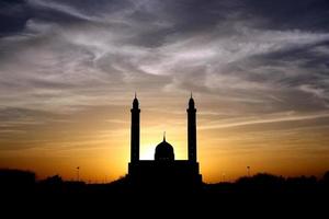 Silhouette of mosque under cloudy sky  photo