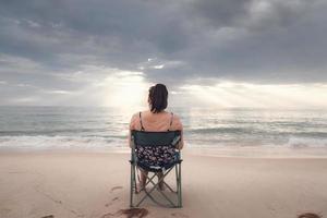 mujer independiente está trabajando en una tableta frente al mar foto