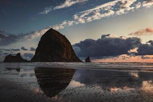 Reflection of monolith Haystack Rock in Oregon photo