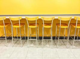 Raw de sillas amarillas en una cafetería. foto