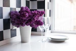 lilacs in a vase and glasses photo