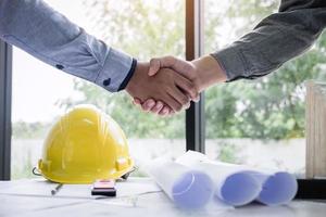 Construction engineers shake hands photo