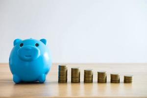  Coin stacks on desk next to piggy bank photo