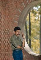 Young man standing inside brick structure photo