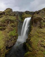 Scenic view of waterfall under a cloudy sky photo