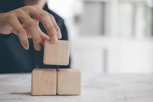 A close-up of a person stacking wooden blocks photo