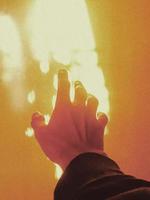 Hand reaching towards light photo