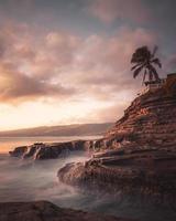 Cliff and ocean at sunset photo