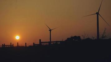 Silhouettes of wind turbines at sunset photo