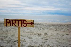 Sign with an arrow at the beach photo