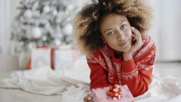 Thoughtful young woman with a Christmas gift video