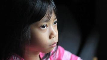pensativa niña asiática mira a la cámara