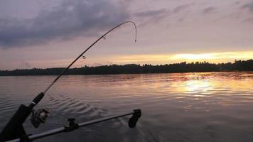 canna da pesca in traina downrigger al tramonto