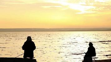 pêcheurs sur le bord de mer calme coucher de soleil video