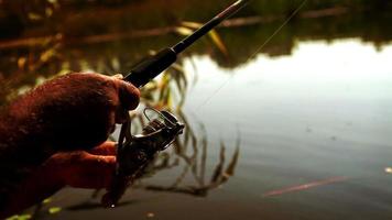 Slow-motion footage of a spinning rod in the hands of a amateur fisherman
