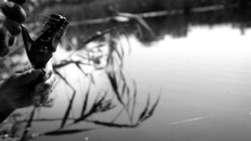 Schwarz-Weiß-Video einer Spule auf einem Löffel-Köder, der von einem Fischer während des Fischens gedreht wurde