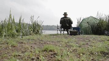 pensionato pesca sulle rive di un lago inglese