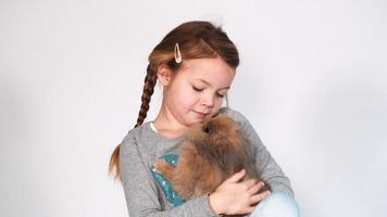 menina brinca e abraça com coelho