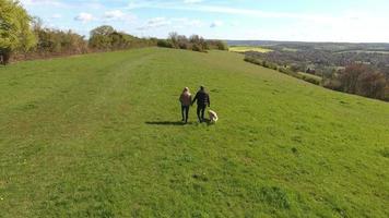 ripresa aerea di coppia matura e cane in passeggiata in campagna