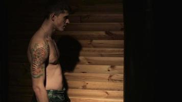Jeune homme s'entraînant avec un sac de boxe dans la salle des arts martiaux mixtes video