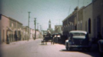 1948: carrozza trainata da cavalli che attraversa le strade urbane. video