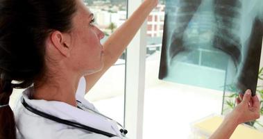 vacker sjuksköterska som håller upp röntgen till fönstret