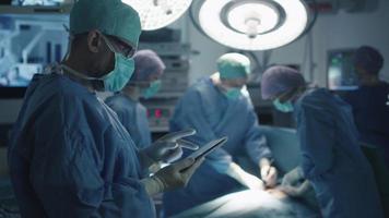 médico usando o tablet na sala de cirurgia. video