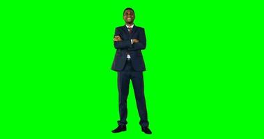 Businessman standing with arms crossed against green screen