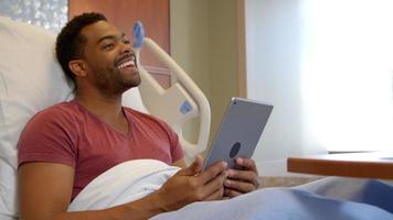 patient i sängen med digital tablett ser sjuksköterska skott på r3d video