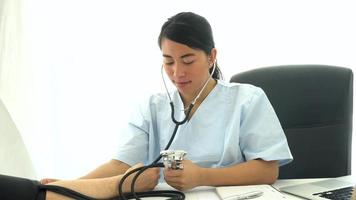 médico asiático medindo pressão arterial