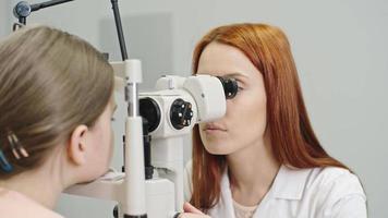 opticien pédiatrique vérifiant les yeux de la jeune fille