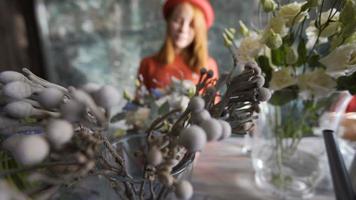 Blumen auf unscharfem Hintergrundfloristenmädchen, das eine Blumenzusammensetzung macht video