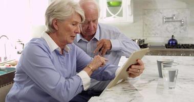 Couple de personnes âgées utilisent une tablette numérique pour l'achat tourné sur r3d video