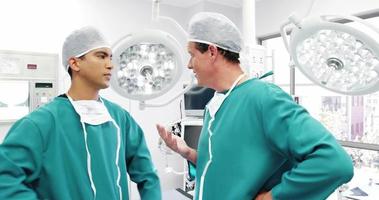 cirurgiões interagindo uns com os outros na sala de operação