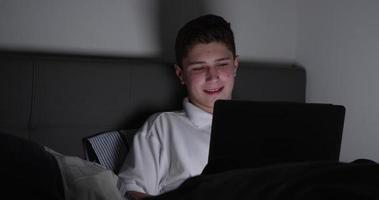 ragazzo adolescente seduto sul divano con laptop a casa girato su r3d video