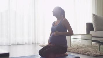 jovem grávida fazendo exercícios na sala de estar em casa video