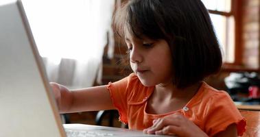 liten flicka som använder bärbara datorn i klassrummet