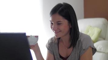 trevlig tjej hemma av sin bärbara dator
