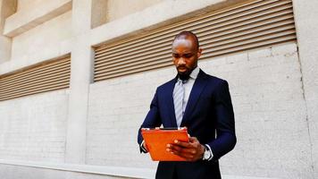 African American businessman stand with tablet outdoors