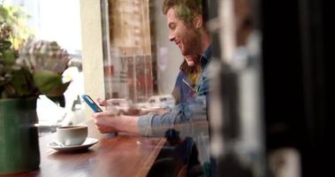 vrouw en man zitten in coffeeshop met tablet