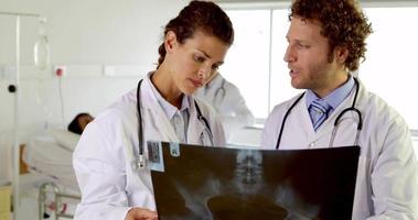 médicos que examinan la radiografía en la sala video